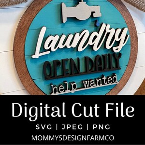 May include: A round wooden laundry sign with a white background and a turquoise center. The sign features the words "Laundry", "Open Daily", and "Help Wanted" in layered lettering. A faucet graphic is at the top.