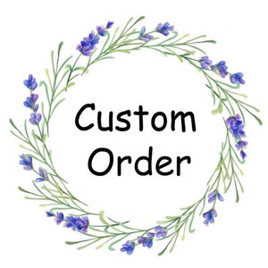 May include: A circular floral wreath with lavender flowers and green leaves encircles the words "Custom Order" in black script. The design is set against a white background, creating a clean and elegant aesthetic.