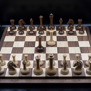 May include: A wooden chessboard with black and white squares. The chess pieces are made of wood and have a dark brown finish. The pieces are arranged in a standard starting position, with the white king and queen in the center of the board. The white king is in check.