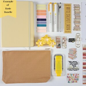 May include: A collection of stationery items, including a beige notebook, highlighters, sticky notes, a pencil, a bookmark, stickers, a reading log, a pencil case, and a yellow stapler. The items are arranged on a white surface.