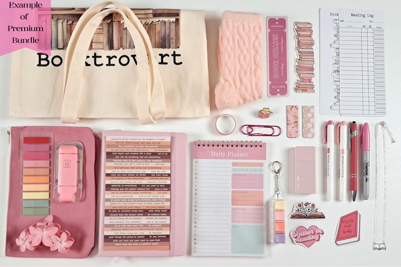 May include: A flat lay of a premium book-themed bundle in shades of pink and cream. Includes a tote bag, planner, socks, stickers, pens, and a reading log. The tote bag reads "Booktrovert".
