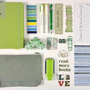May include: A collection of stationery items, including a green notebook, highlighters, pens, bookmarks, stickers, and a pencil case. The text "Example of Basic Bundle" is in the upper left corner. The items are arranged on a white surface.