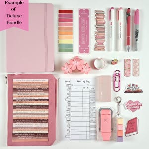 May include: A pink deluxe bundle with a notebook, sticky notes, bookmarks, pens, highlighters, and stickers. The bundle includes a reading log, a pink paper clip, and a keychain with colorful cubes. The text "BOOK GIRLIES" is visible.
