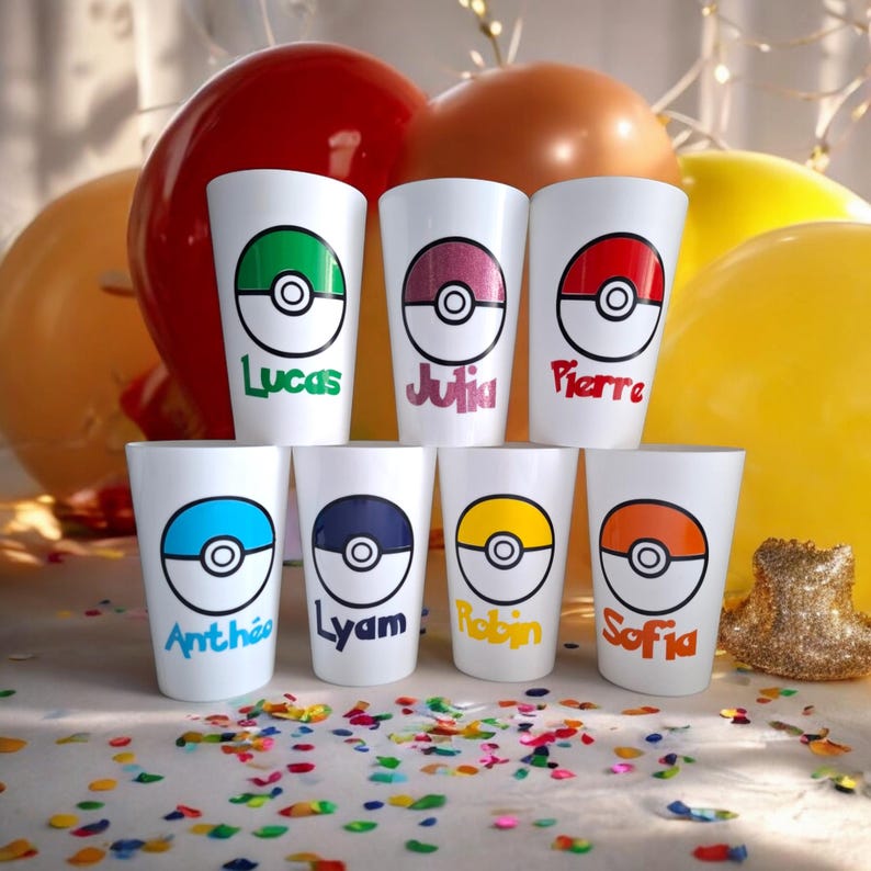 May include: Seven white plastic cups with a Pokeball design and names printed on the front. The cups are arranged in a semi-circle on a white surface with colorful confetti.