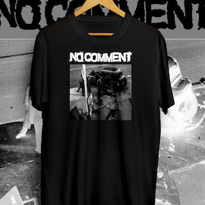 May include: Black t-shirt with a white graphic of a car crash and the text "NO COMMENT" printed on the front.