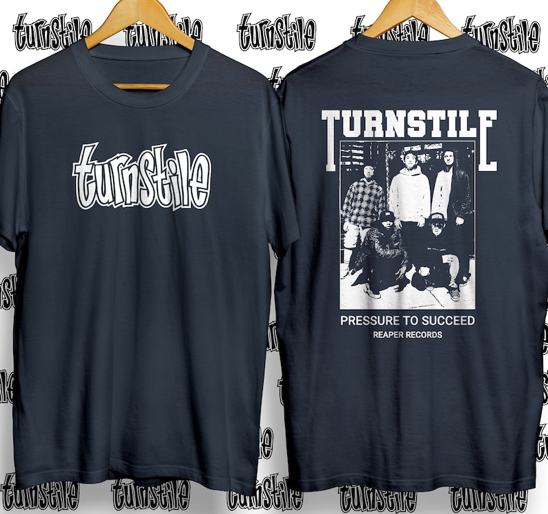 Puede incluir: Una camiseta azul marino con un gr&aacute;fico blanco de la banda Turnstile. La parte posterior de la camiseta presenta una foto en blanco y negro de la banda con el texto "TURNSTILE", "PRESSURE TO SUCCEED" y "REAPER RECORDS".