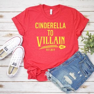 May include: Red t-shirt with yellow text that reads "Cinderella to Villain Est 2019" with a yellow KC logo.