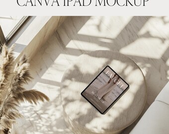 Op de afbeelding: Een iPad-mockup met de tekst "CANVA IPAD MOCKUP" bovenaan. De iPad toont een magazinecover met de namen "FAUGET" en "RENEE MILLER". De iPad ligt op een ronde, beige poef, met zonlicht en schaduwen.
