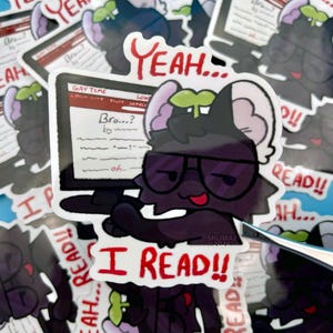Peut inclure: Un autocollant représentant un personnage de dessin animé avec une fourrure sombre, des lunettes et une langue rouge, tenant un écran d'ordinateur. L'écran affiche du texte, et l'autocollant comprend les phrases "Yeah..." et "I READ!!".