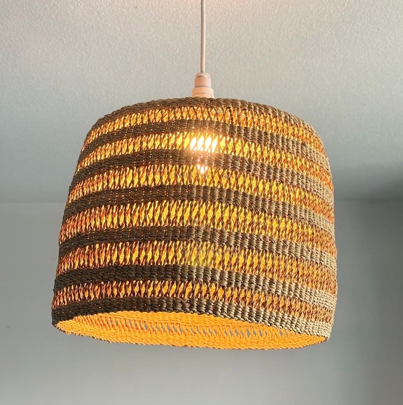 K&ouml;nnte beinhalten: Gewebte Pendelleuchte mit Streifenmuster in Braun- und Beiget&ouml;nen. Die Leuchte h&auml;ngt an einem wei&szlig;en Kabel und strahlt warmes Licht aus. Der Schirm hat eine runde Form, geeignet f&uuml;r die Inneneinrichtung. Durchmesser ca. 30 cm.