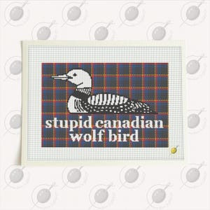 May include: A framed needlepoint featuring a white and black bird design on a plaid background of blue, red, and yellow. The text "stupid canadian wolf bird" is below the bird.
