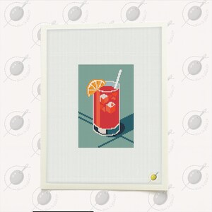 May include: A cross-stitch artwork featuring a pixelated cocktail in a tall glass with ice cubes and an orange slice. The drink is a vibrant red color, set against a teal background with a white frame. A white straw is visible.