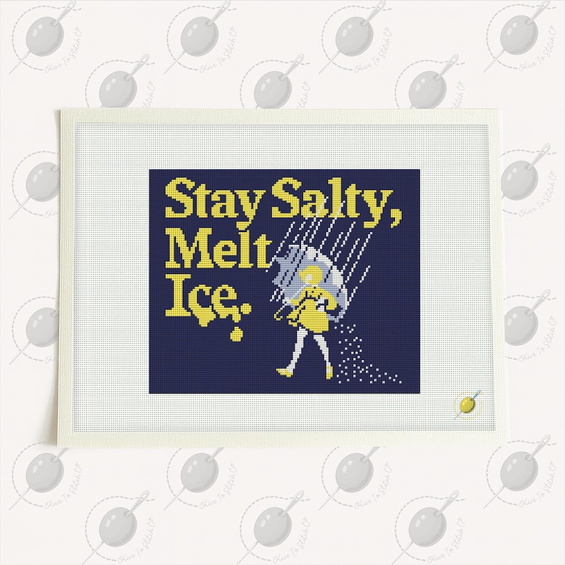 May include: A needlepoint canvas with the text "Stay Salty, Melt Ice." in yellow on a navy blue background. The image includes a yellow figure with an umbrella and salt. The canvas is framed in white.