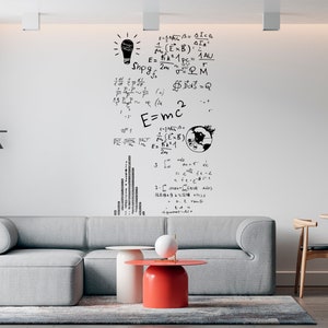 May include: A white wall with black handwritten equations and a lightbulb drawing. The wall is in a living room with a gray sectional sofa, two round coffee tables, and a wooden dining table with chairs.