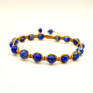 Peut inclure: Bracelet fait à la main avec des perles de pierres précieuses bleu vif enfilées sur un cordon brun doré. Le design macramé réglable permet un ajustement confortable. Parfait pour ajouter une touche de couleur à n'importe quelle tenue.