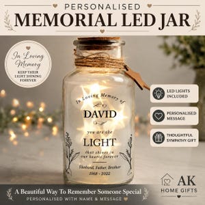 May include: A clear glass jar with a cork stopper and twine wrapping around the neck. The jar contains warm LED string lights and features black printed text that reads: In Loving Memory of DAVID you are the LIGHT that shines in our hearts forever Husband, Father, Brother 1968 - 2022.