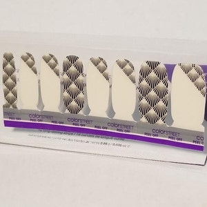 Puede incluir: Un conjunto de 16 tiras de esmalte de uñas en un paquete de plástico transparente. Las tiras presentan un patrón geométrico con acentos en blanco y negro. El paquete incluye el texto "colorSTREET PEEL OFF".