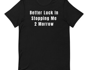 May include: A black short-sleeved t-shirt featuring the white text Better Luck In Stopping Me 2 Morrow printed in a clean sans-serif font across the chest. The garment has a crew neckline and a standard fit, showcasing a simple design.