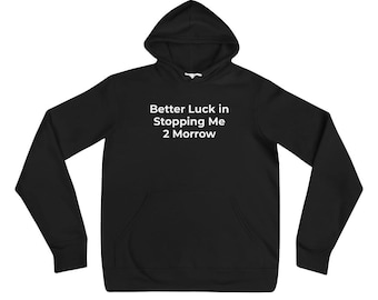 May include: A black long-sleeve hooded sweatshirt featuring a front kangaroo pocket and white text printed on the chest that reads: Better Luck in Stopping Me 2 Morrow. The garment includes a matching drawstring hood and ribbed cuffs.