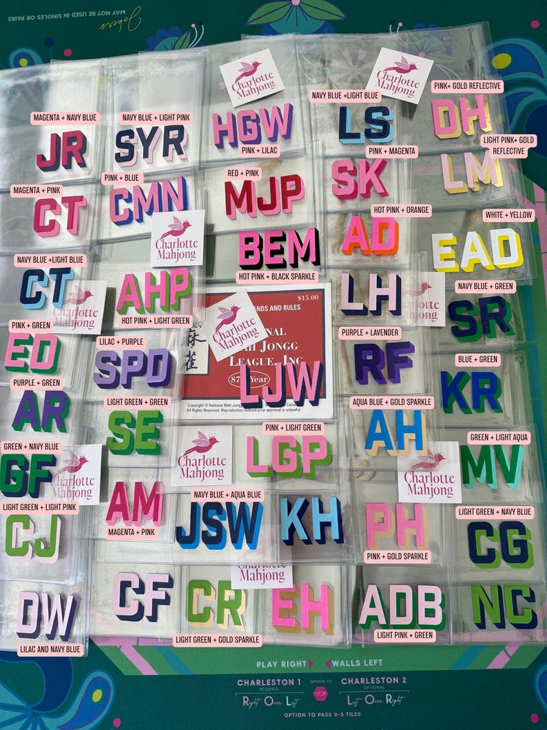 May include: A collection of individual Mahjong tile stickers featuring various two-letter and three-letter combinations in diverse color schemes. Each sticker is labeled with its specific color palette, such as pink, navy blue, and gold sparkle.