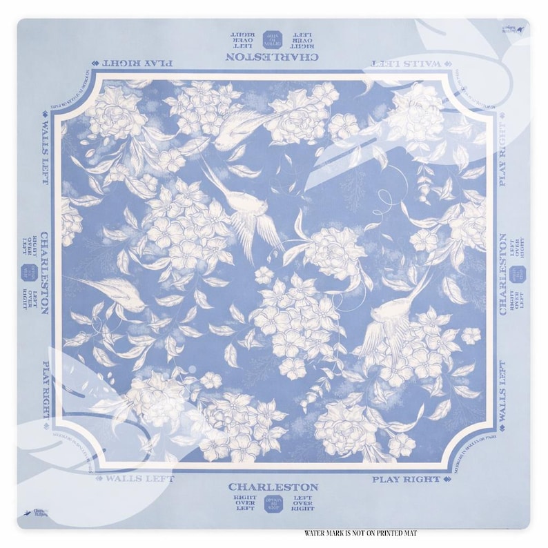 Puede incluir: Una alfombra cuadrada azul claro con un dise&ntilde;o floral y de p&aacute;jaros. El dise&ntilde;o presenta flores y p&aacute;jaros blancos sobre un fondo azul. Las palabras "Charleston" y "Walls Left" est&aacute;n impresas en la alfombra.