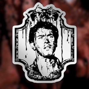 Könnte beinhalten: Ein schwarz-weißer Aufkleber mit einem Porträt eines Mannes mit verstörtem Gesichtsausdruck. Das Porträt ist mit einem dekorativen Rahmen und tropfenden Akzenten versehen. Der Aufkleber hat einen weißen Hintergrund und eine Schleife oben.