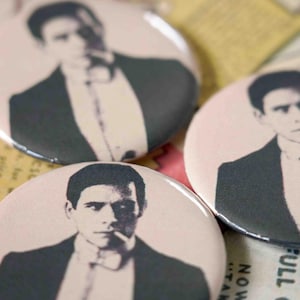 May include: Three circular badges featuring a black and white image of a person in a suit, smoking a cigarette. The badges have a pale pink background. The badges are on a background of vintage paper.