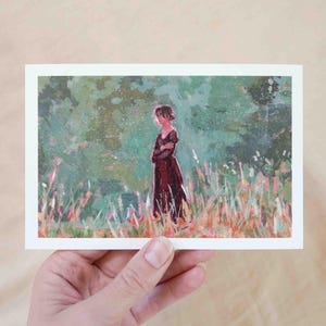 May include: A postcard with an illustration of a person in a long, dark red dress standing in a field of tall grass. The background is a blend of green and light colours, creating a soft, painterly effect.