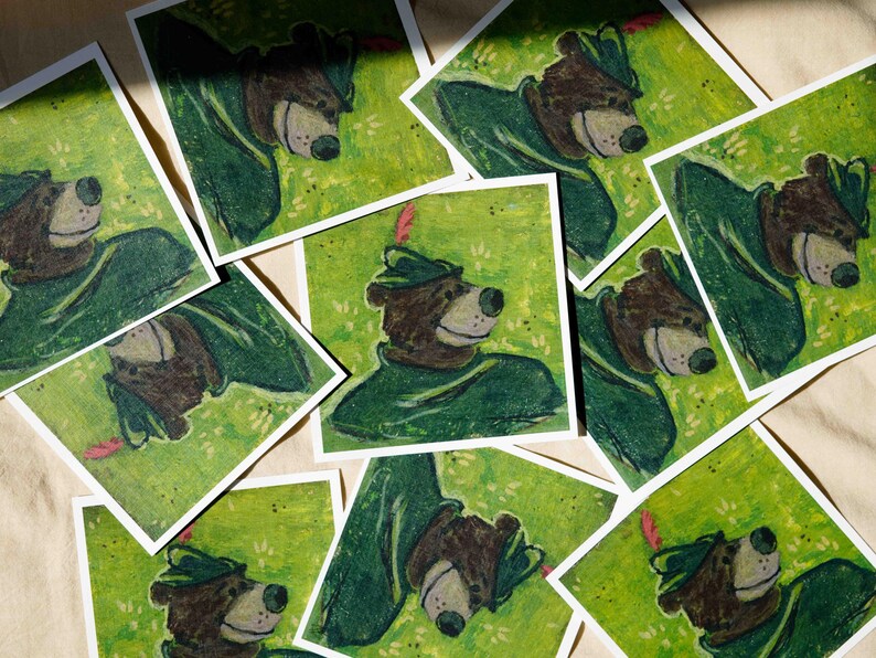 May include: A collection of vintage illustrations featuring a cartoon bear wearing a green hat and a green outfit. The illustrations are printed on white paper and have a green background.
