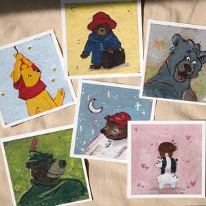 May include: A collection of six square art prints featuring bear characters in various scenes. The prints showcase illustrations of bears in different settings, including Winnie the Pooh, Paddington Bear, and others, with a whimsical and colorful style.