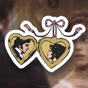 May include: A pair of gold heart-shaped lockets with a pink ribbon. The lockets are open and show a black and white illustration of a couple inside.