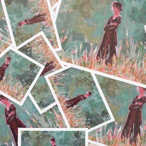 May include: A selection of art prints depicting a woman in a long brown dress in a field. The artwork has a painterly style with a green and orange colour palette. The prints are arranged in a scattered pattern.