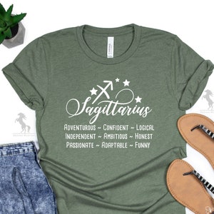 May include: Green t-shirt with white text that reads "Sagittarius" and lists personality traits: "Adventurous - Confident - Logical - Independent - Ambitious - Honest - Passionate - Adaptable - Funny".