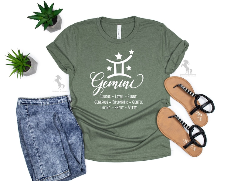 Op de afbeelding: Groen T-shirt met een wit Tweelingen sterrenbeeld en de tekst "Nieuwsgierig - Trouw - Grappig - Grootmoedig - Diplomatiek - Lief - Liefdevol - Slim - Grappig".