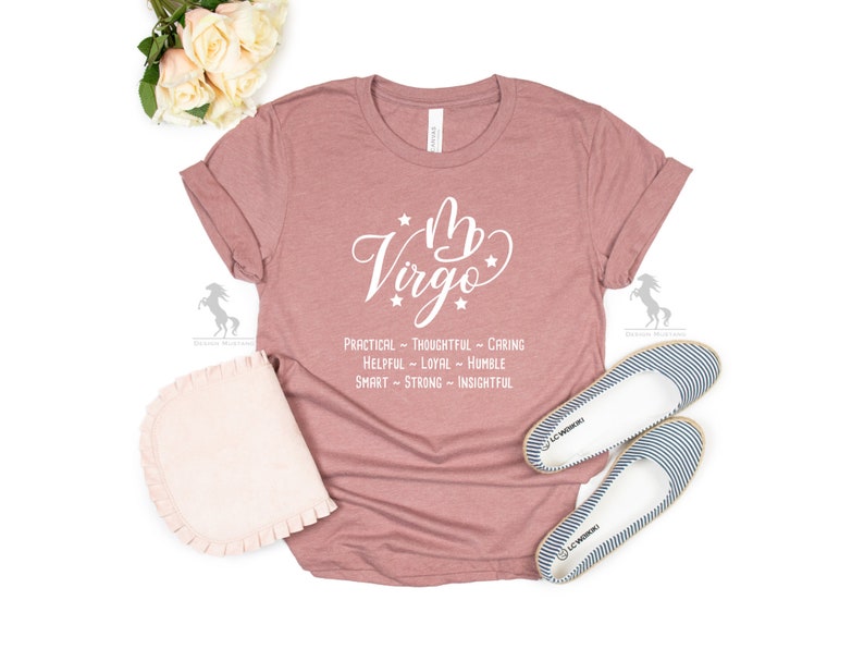 May include: A dusty rose colored t-shirt with the Virgo zodiac symbol and the words "Virgo" in white. Below the symbol are the words "Practical - Thoughtful - Caring - Helpful - Loyal - Humble - Smart - Strong - Insightful".