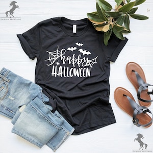 May include: Black t-shirt with a white graphic that says "Happy Halloween" with bats and spiderwebs.