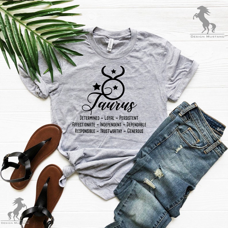 May include: A gray t-shirt with a black Taurus zodiac symbol and the words "Taurus", "Determined", "Loyal", "Persistent", "Affectionate", "Independent", "Dependable", "Responsible", "Trustworthy", and "Generous" printed on it.