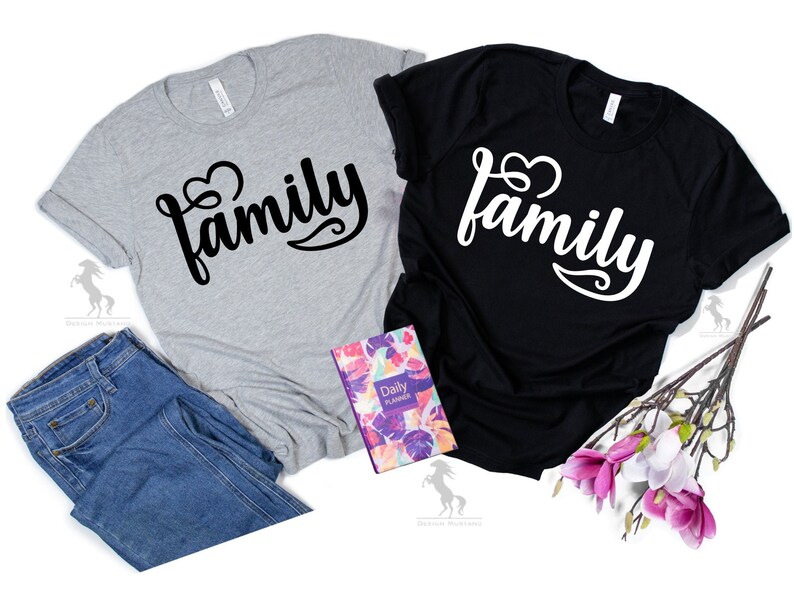 May include: Two t-shirts with the word "family" written in a stylized font with a heart symbol. One shirt is gray with black text and the other is black with white text.