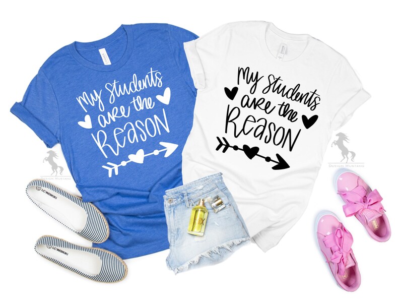 Op de afbeelding: Twee T-shirts met de tekst "Mijn leerlingen zijn de reden" erop. E&eacute;n shirt is blauw en de andere is wit. Beide shirts hebben een hart- en pijlontwerp.