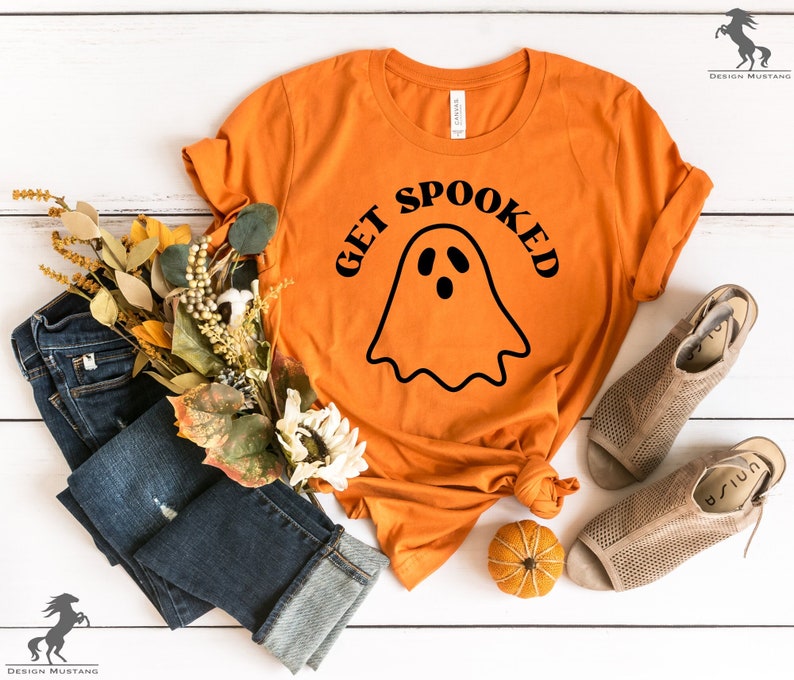 K&ouml;nnte beinhalten: Orangefarbenes T-Shirt mit einem schwarzen Geistermotiv und dem Text "Get Spooked".