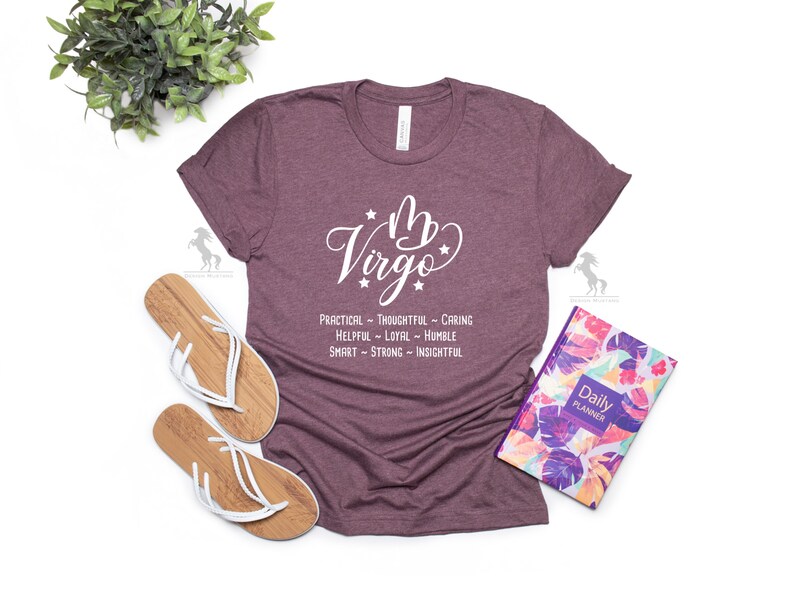 May include: A maroon t-shirt with a white graphic of the astrological sign Virgo and the text "PRACTICAL - THOUGHTFUL - CARING HELPFUL - LOYAL - HUMBLE SMART - STRONG - INSIGHTFUL".