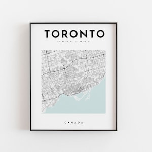 Puede incluir: Impresión enmarcada en negro con un mapa detallado de Toronto, Canadá. El mapa de la ciudad es en blanco y negro, con una sección azul claro que representa el lago Ontario. La palabra "TORONTO" está en la parte superior, con "CANADA" en la parte inferior.
