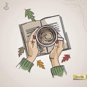 May include: An embroidered design featuring hands holding a coffee cup over an open book, with autumn leaves scattered around. The hands have red nail polish and green sleeves. The word "DIGITAL" is in a gold rectangle.