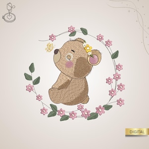 Könnte beinhalten: Gesticktes Design eines sitzenden braunen Teddybären mit Blumenkranz, umgeben von einem Kranz aus rosa Blumen und grünen Blättern. Ein gelber Schmetterling schwebt in der Nähe der Nase des Bären. Das Wort "DIGITAL" steht in einem goldenen Rechteck.
