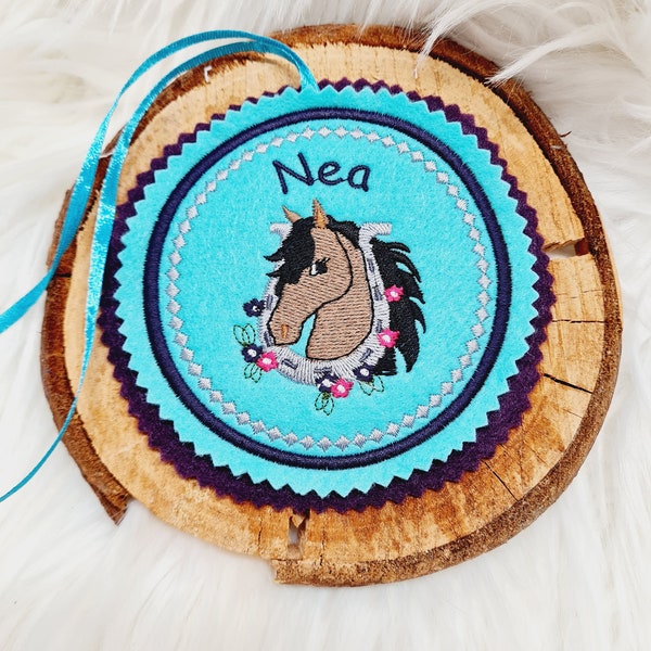 Horse/pony in a lucky horseshoe. Individually embroidered button for the school cone or book bag.