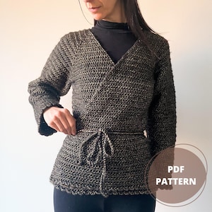 May include: A black and gold crochet wrap with a tie belt. The wrap has a V-neck and long sleeves. The text "PDF PATTERN" is visible in the lower right corner of the image.