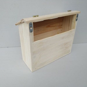 May include: A wooden wall-mounted mailbox with a hinged lid and a natural wood finish.