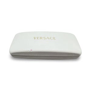 May include: A white rectangular case with rounded edges. The word "VERSACE" is printed in gold on the top. The case appears to be made of a textured material, possibly leather or a leather-like substance.