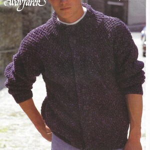 May include: A purple knitted cardigan with a button closure. The cardigan is made with a textured yarn and has a simple design. The text "wayfarer" is written in cursive on the image. The text "Easy knit" is also on the image.