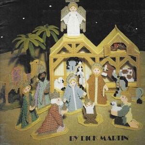 May include: A plastic canvas nativity scene with a star, angel, and figures of Mary, Joseph, baby Jesus, and the three wise men. The scene is set in a stable with a camel, donkey, and sheep. The title "The Nativity in Plastic Canvas" and the name "By Dick Martin" are printed below the scene.